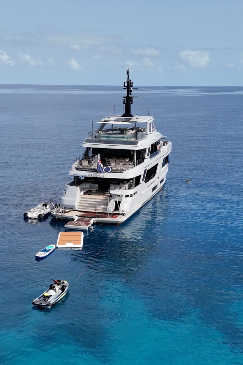 Pazienza anchored with water toys deployed in turquoise Pacific waters